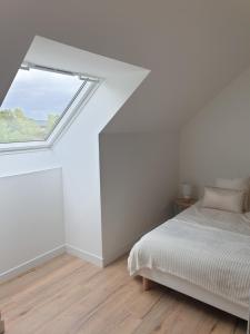 een witte slaapkamer met een bed en een raam bij Studio n°6 Henriville in Amiens
