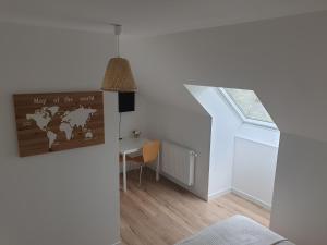 een witte kamer met een bureau en een raam bij Studio n°6 Henriville in Amiens