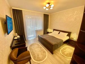 Habitación de hotel con cama y silla en Сонячне Джерело, en Polyana