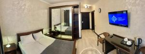 a hotel room with a bed and a tv at Сонячне Джерело in Polyana
