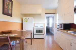 a kitchen with a table and a white refrigerator at Relax in unpretentious peaceful and authentic house with public transportation cafes and U of Berkeley close by in Albany