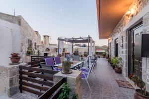 a patio with purple chairs and tables on a building at Zaros Villa Fountarinis in Zaros