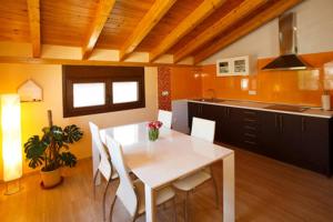 a kitchen with a white table and white chairs at MIRARIBERA en la Ribera del Duero in Fompedraza
