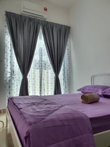 a bedroom with a purple bed and a window at Muslim Homestay D'Bertam, Kepala Batas, Penang in Kepala Batas