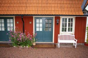 dom z niebieskimi drzwiami i ławką w obiekcie Oxgården w mieście Vimmerby