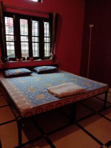 a small bed in a room with a window at Tebaar Backpackers in Rishīkesh