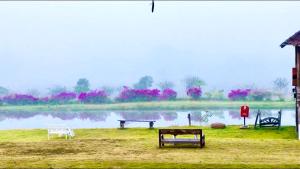 a body of water with benches next to a lake at Vimarnkiri Resort in Pai