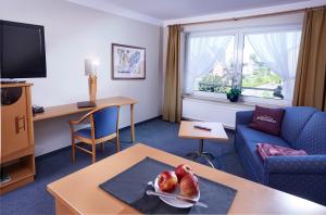 a living room with a couch and a table at Hotel-Restaurant Schünemann in Steinfurt