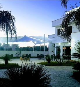 - un bâtiment blanc avec un parasol devant dans l'établissement Hotel Costa Blu, à Sant'Isidoro