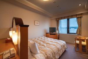 A bed or beds in a room at Hida Takayama Onsen Hida Hotel Plaza