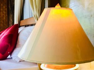 eine Lampe, die neben einem Bett sitzt in der Unterkunft Vimarnkiri Resort in Pai