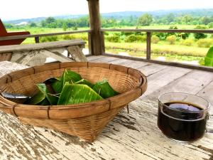 a basket of greens sitting on a table with a drink at Vimarnkiri Resort in Pai