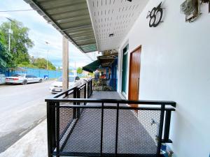 a balcony with a black railing next to a street at The 83 Betong GuestHouse in Betong