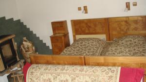 a bedroom with two beds and a tv at Drevenica Goralský Dvor in Ždiar