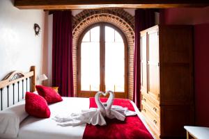 a bedroom with a bed with a white swan on it at Posada La Fabula in Santillana del Mar