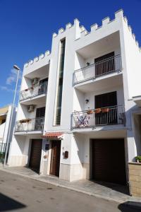 un immeuble d'appartements blanc avec deux garages dans l'établissement B&B La Strea, à Porto Cesareo