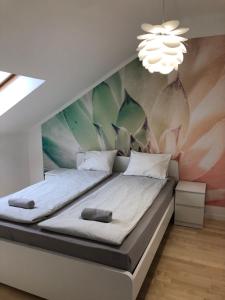 ハイドゥソボスローにあるSunrise 2 Apartmentの壁に壁画が施されたベッドルーム1室(ベッド2台付)