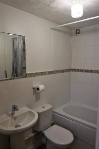 een badkamer met een toilet, een wastafel en een bad bij Palmers Apartment A in Bristol