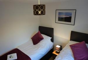 een slaapkamer met 2 bedden met paarse kussens bij Palmers Apartment A in Bristol