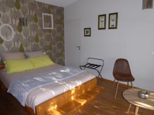 a bedroom with a bed and a chair and a table at Le bois du drillais in La Gaubretière
