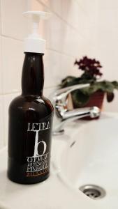 a bottle of liquid soap sitting on a bathroom sink at Casa das Flores in Santo Tirso