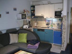 ein Wohnzimmer mit einem Sofa und einer Küche in der Unterkunft Ferienwohnung R & W Schulz in Altenau