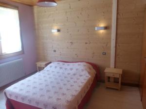 een slaapkamer met een bed en twee nachtkastjes bij Le Fayet d'en haut in Abondance
