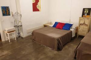 1 dormitorio con 1 cama con almohadas azules y rojas en El Piset de Amposta - Delta del Ebro, en Amposta