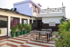 un patio con mesa, sillas y plantas en Hotel Thakur Ji, en Haridwar