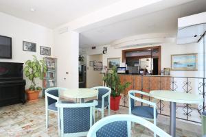a restaurant with tables and chairs and a counter at Hotel Daisy in Marina di Massa