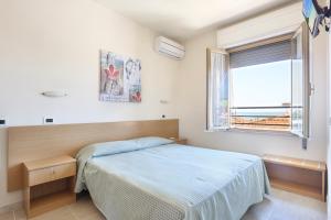 a bedroom with a bed and a window at Hotel Daisy in Marina di Massa