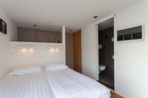 
a bedroom with a white bed and white walls at Houseboat Little Amstel in Amsterdam
