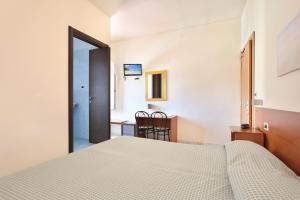 1 dormitorio con 1 cama y 1 mesa con silla en Hotel Daisy en Marina di Massa