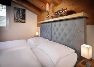 a bedroom with a bed with a headboard and a table at Fewo-Obertauern Alps in Obertauern