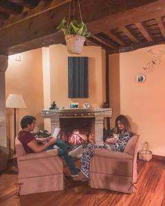 a group of people sitting in chairs in front of a fireplace at Posada de Candelario in Candelario