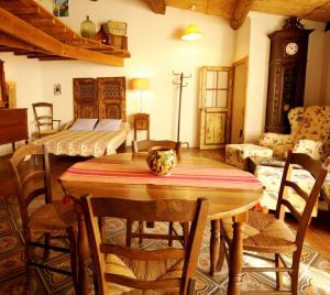 a living room with a wooden table and a bedroom at La Vigne Bleue in Olonzac