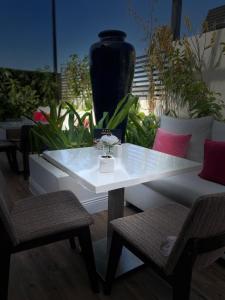 a white table with two chairs and a black vase at Dana Hotel & Residences in Riyadh