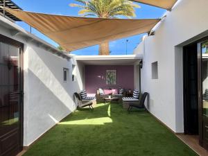 プエルト・デル・カルメンにあるCasa OASIS en Puerto del Carmenのパティオ(椅子、ソファ、テーブル付)