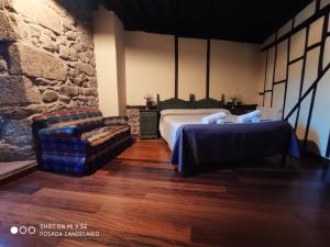 a bedroom with a bed and a couch and a chair at Posada de Candelario in Candelario +148 photos