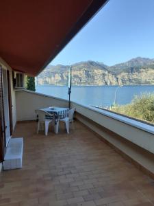 a balcony with a table and a view of the water at Residence Le Palme appartamenti in Malcesine