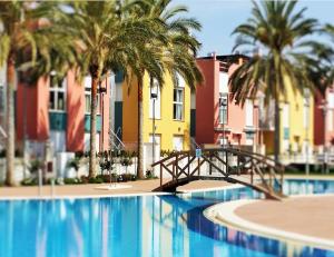 a swimming pool with a bridge and palm trees at Tu Hogar en Verazul in Vera