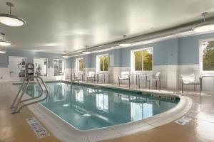 a large swimming pool with chairs in a building at Holiday Inn Express Hotel & Suites Binghamton University-Vestal, an IHG Hotel in Vestal