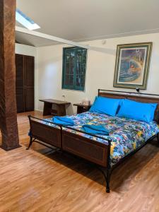 a bedroom with a large bed with blue pillows at Rainforest Hideaway in Cape Tribulation
