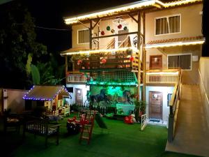una casa con parque infantil en el patio por la noche en Pousada Alegria do Cowboy en Penha