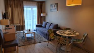 - un salon avec un canapé bleu et une table dans l'établissement Apartament Czarna Góra Is1, à Sienna