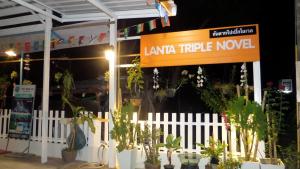 a white fence with plants in front of a store at Lanta Triple Novel in Ko Lanta