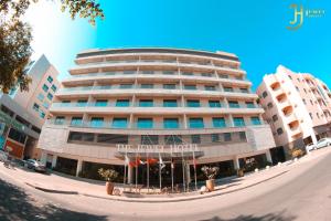 un gran edificio con un cartel delante en The Jewel Hotel, en Manama