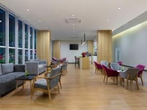 a lobby with couches and tables and chairs at favehotel Karawang in Karawang