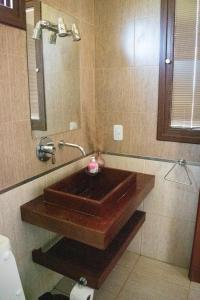 Un baño con lavabo de madera y espejo. en Aires del Norte, en Federación