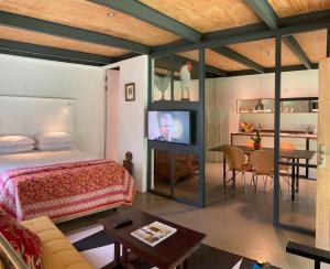 um quarto com uma cama e uma mesa com uma televisão em Guest House at 118 by PWM Architects em Joanesburgo
